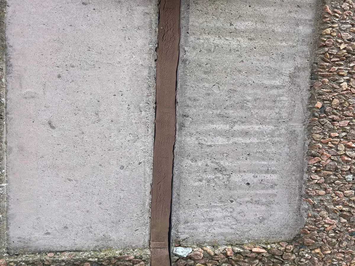 Porøse og nedslidte fuger mellem betonelementer før fugeudskiftning på facade.